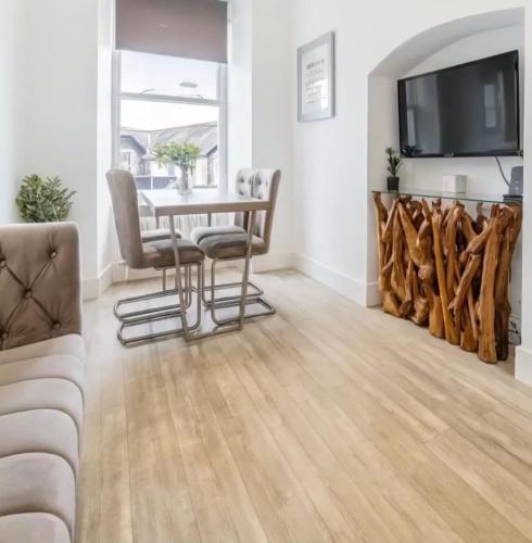 a living room with a table and chairs and a tv at Ambleside Apartment - Central - Dog Friendly in Ambleside