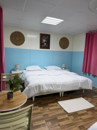 a large bedroom with two beds and a table at استراحة الأسطورة AlAstura rest in Al Ḩamrāʼ