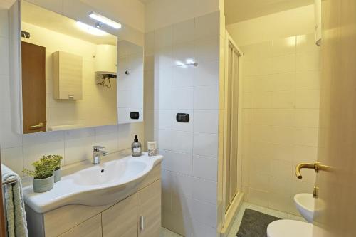 a white bathroom with a sink and a mirror at Maison Clocher in Pré-Saint-Didier