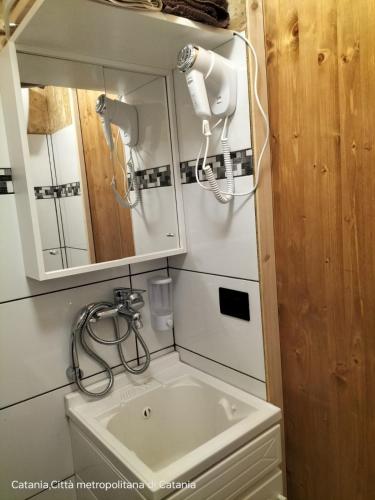 a bathroom with a sink and a mirror at Mini casa a 30 mt dalla spiaggia in Catania