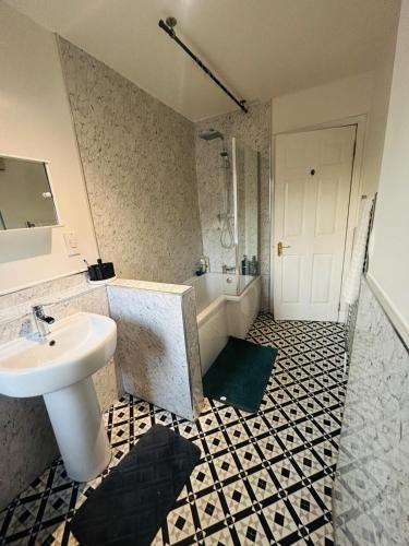 a bathroom with a sink and a toilet and a tub at Modern & cozy 2 bedroom flat in Dundee