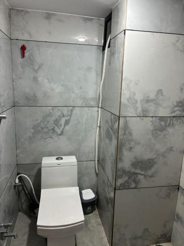 a small bathroom with a toilet and a shower at MP Homestay in Godarpura