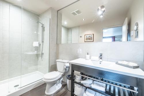 a bathroom with a toilet and a sink and a shower at Petit Hôtel - Café Krieghoff in Quebec City