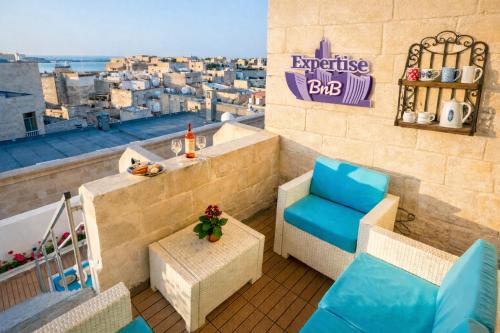 a balcony with a table and chairs and a view at Kharmen A 1565s House with Seaviews in Birgu