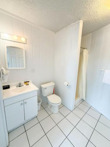 a white bathroom with a toilet and a sink at 10 Branch Bungalow Treetop in Four Seasons