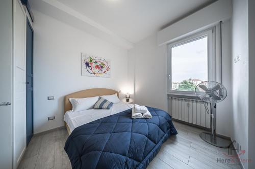 a bedroom with a bed and a window and a fan at Modern Central Space - Mare 5 min - AC - WiFi in Savona
