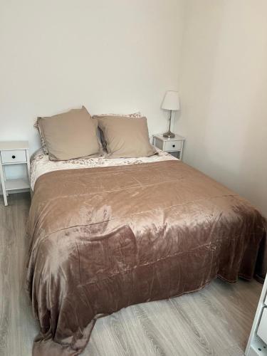 Appartement maisonnette في فوس-سور-مير: سرير في غرفة نوم بها طاولتان جانبيتان وطاولتان