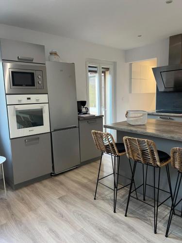 Appartement maisonnette في فوس-سور-مير: مطبخ مزود بأجهزة من الفولاذ المقاوم للصدأ وطاولة مع كراسي