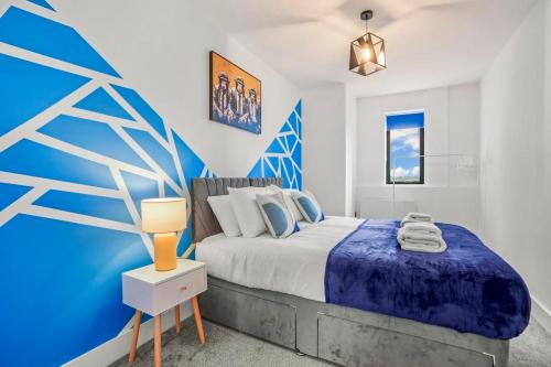 a bedroom with a bed and a blue wall at City centre FREE Parking Families and Contractors Sleeps 5 with a view in Norwich