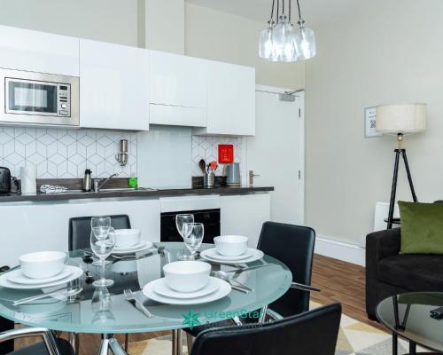 a kitchen and dining room with a glass table and chairs at GreenStar Apartments Dundee - Short Walk Away Into Dundee City Centre - CLICK FOR OPTIONS - 6 PROPERTIES AVAILABLE FROM 1 TO 3 BEDROOMS ALL IN SAME BUILDING IDEAL FOR GROUP STAYS in Dundee