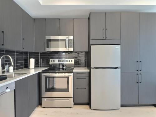 a kitchen with stainless steel appliances and white cabinets at Modern Studio, Gym, Near UAB in Birmingham