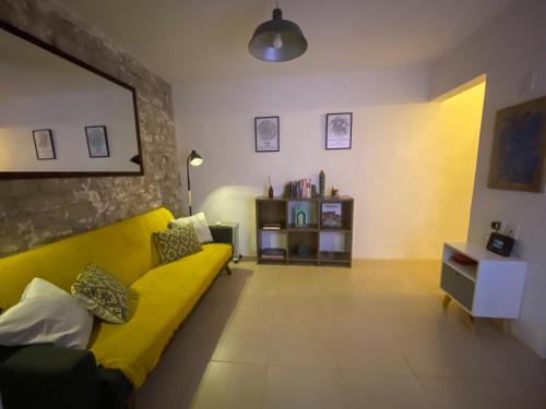 a living room with a yellow couch and a table at Cozy Flat Condesa in Mexico City