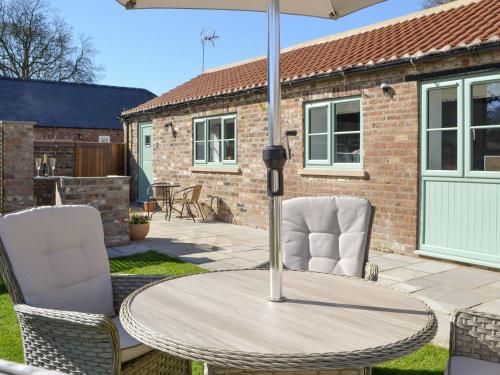 a table and chairs on a patio with an umbrella at The Stables - Uk13196 in Butterwick
