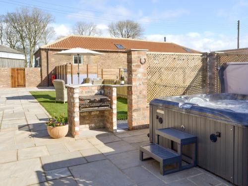 a backyard with a hot tub and a grill at The Stables - Uk13196 in Butterwick
