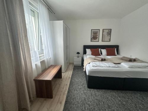 a bedroom with two beds and a table and a window at Apartment Lale - Frankenwald, Waldblick & Rennsteig in Steinbach am Wald