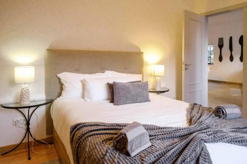 a bedroom with a large white bed with two tables at Casa dos Andrades in Sesimbra