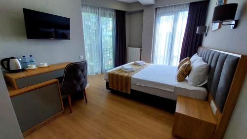 ein Hotelzimmer mit Bett, Schreibtisch und Fenster in der Unterkunft Falcon Hotel in Tbilisi City