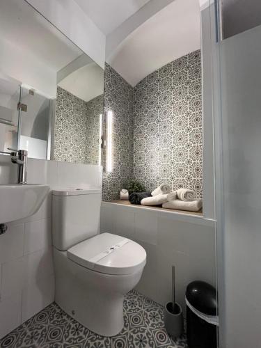 a white bathroom with a toilet and a sink at Cool Guest House in Elvas