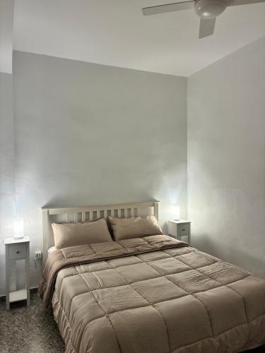 a bedroom with a large bed and two night stands at El Chalet de Lola in Playa de Miramar