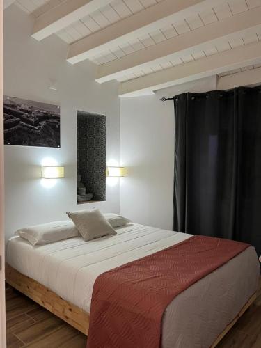 a bedroom with a large bed with black curtains at Cool Guest House in Elvas
