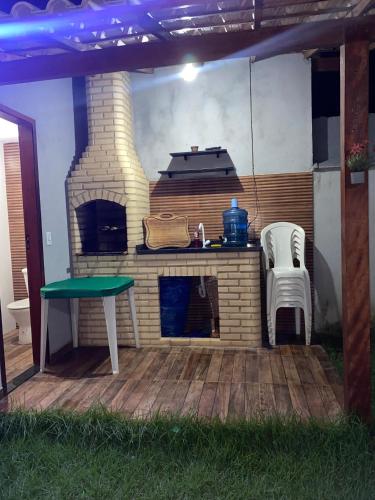 un patio con forno a legna, tavolo e sedia di Casa Diamante a Angelim