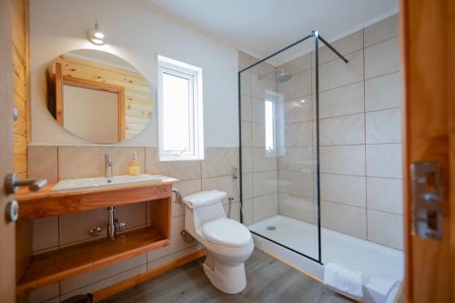 a bathroom with a toilet and a sink and a shower at Vuelta al Sur in Puelo