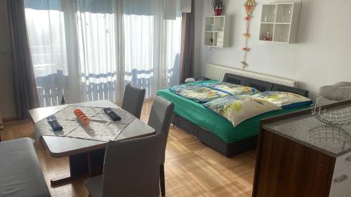 a bedroom with a bed and a table and a dining room at Wohnhaus City Süd in Herzogsdorf