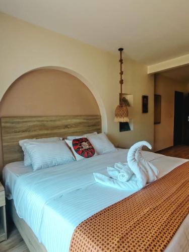 a bedroom with a large bed with white sheets at Nubian Hotel in Cairo