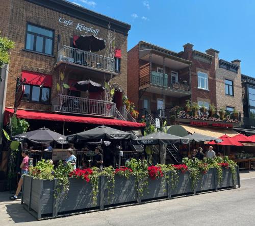 a restaurant with tables and umbrellas in front of a building at Petit Hôtel - Café Krieghoff in Quebec City
