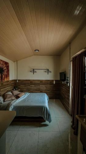 a bedroom with a large bed in a room at Espaços Cardoso, AURORA - luz e leveza in Igrejinha