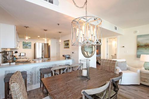 a dining room and kitchen with a table and a chandelier at One Seagrove Place 0205 in Santa Rosa Beach