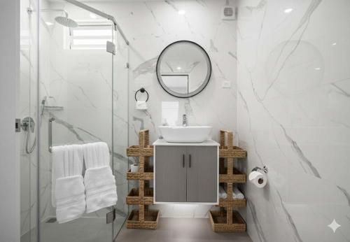 a white bathroom with a sink and a mirror at Bay View by Otium in Catano