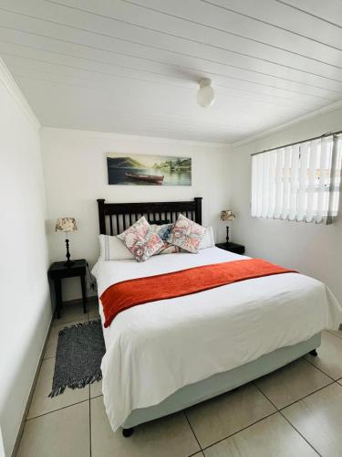 a bedroom with a large bed with a red blanket at Covenant Place in Cape Town