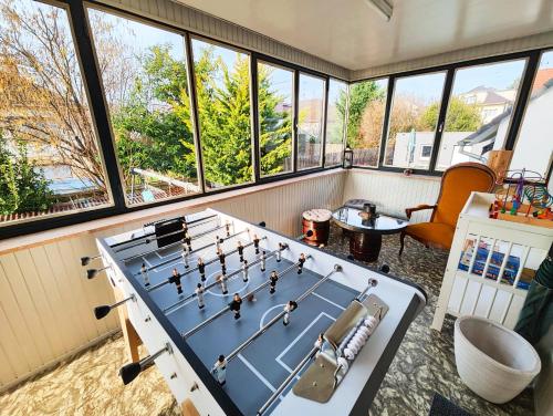 a room with a pool table in a room with windows at Le repère des amis - 4 pers - proche tram - parking gratuit - babyfoot in Lingolsheim