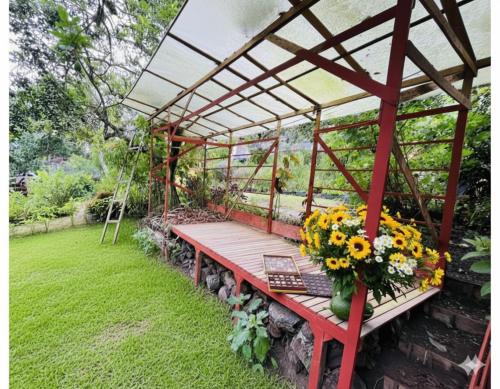 a pergola with a bench and flowers on it at Tipi Miramelinda in Baños
