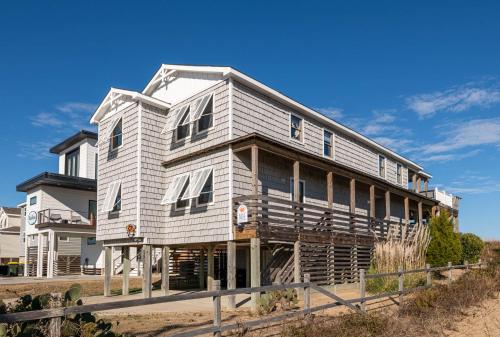 a large house is shown on a beach at T.L. Sea - KDH MP 6, Oceanfront, Ocean view, Rec Room, Spacious Decks, Private Walk to Beach in Kill Devil Hills