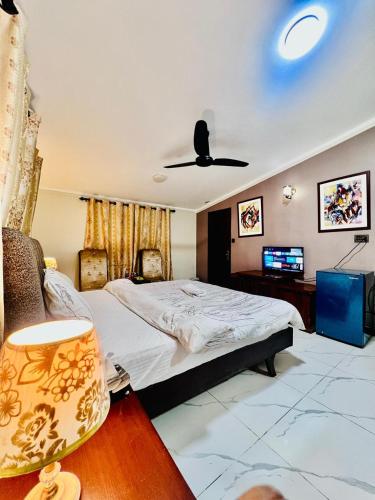 a bedroom with a bed and a ceiling fan at Waves Guest House Clifton Khi in Karachi