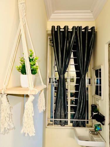 a bathroom with a window with black curtains at Namma Suites 1BHK Serviced Apartment near NIMHANS & St Johns hospital in Bangalore