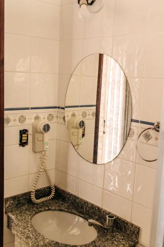 a bathroom with a sink and a mirror at Niv's Hotel in Monte Sião
