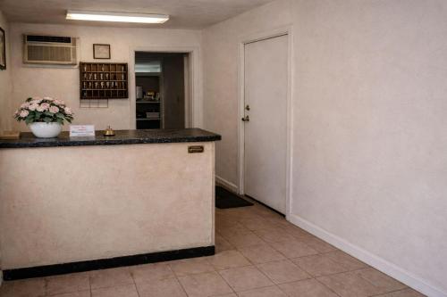a kitchen with a counter and a hallway with a door at Siesta Motor Inn Kissimmee Near Disney World in Kissimmee