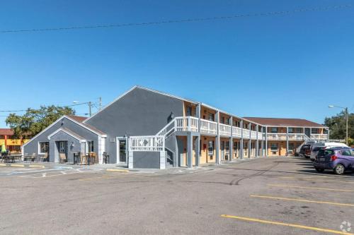 a large building with cars parked in a parking lot at Siesta Motor Inn Kissimmee Near Disney World in Kissimmee