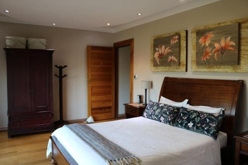 a bedroom with a bed with a wooden headboard at Highland Gate Golf & Trout Estate, House 925 in Dullstroom