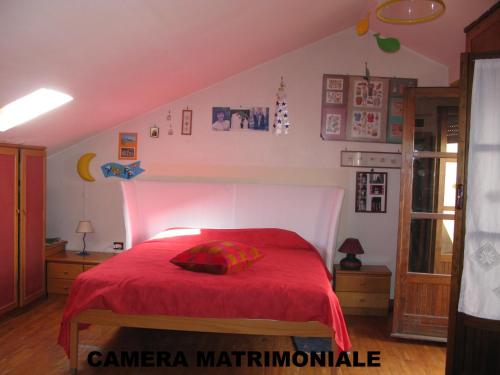 a bedroom with a red bed with a red blanket at casaNARDIELLO in Capua