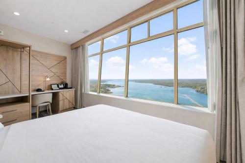 a bedroom with a large bed and a large window at Tower Hotel at Fallsview in Niagara Falls