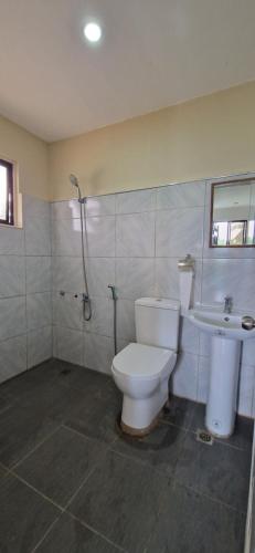 a bathroom with a toilet and a sink at Wengsmont in Tubod