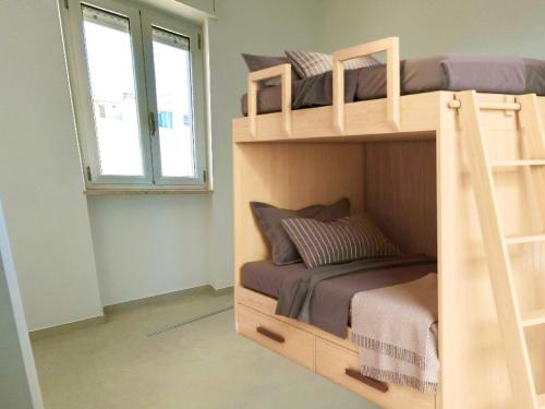 a bedroom with two bunk beds and a window at Sea Apartment - Torre Pali in Torre Pali