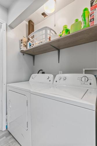 a laundry room with a washer and dryer at Abstract Haven | Stylish 1BR by Tower Grove in Saint Louis