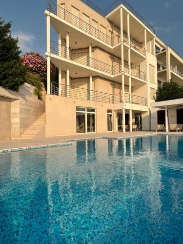 a large swimming pool in front of a building at Luxury Seafront Villa Rezevici in Reževići
