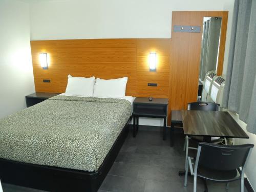 a bedroom with a bed and a table and a desk at SOFI MOTEL in Los Angeles