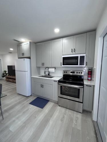 a kitchen with white cabinets and a stove and refrigerator at Sweet home in Miami in Miami